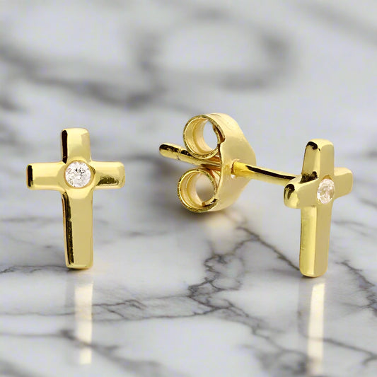Gold cross-shaped earrings with clear gemstones on a white background