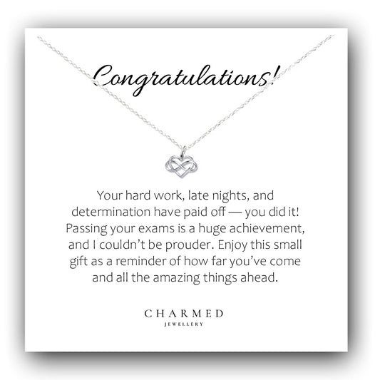 Necklace with a message card congratulating someone on passing exams, featuring the brand 'Charmed Jewellery'.